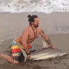 Man pulls shark from the sea to take photos with it