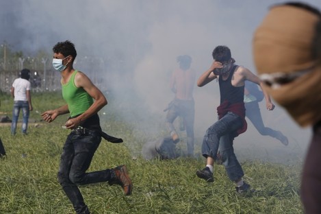 Migrant men coming under fire with tear gas at the Macedonian border 