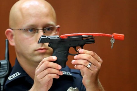 Sanford police officer Timothy Smith holds up the gun that was used to kill Trayvon Martin.