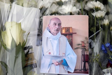 A picture of late Father Jacques Hamel is placed on flowers at the makeshift memorial in front of the city hall close to the church where he was killed. 