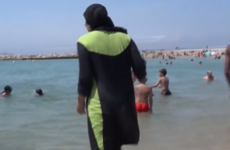 Photos have emerged of armed French police telling a woman to remove a 'burkini'