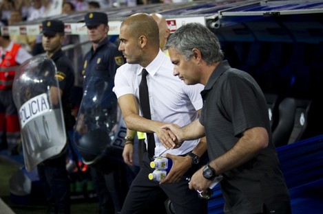 In this Sunday Aug. 14, 2011 file picture, the then Real Madrid's coach Jose Mourinho from Portugal, right, shakes hands with former Barcelona's coach Josep Guardiola before their Super Cup first leg soccer match.