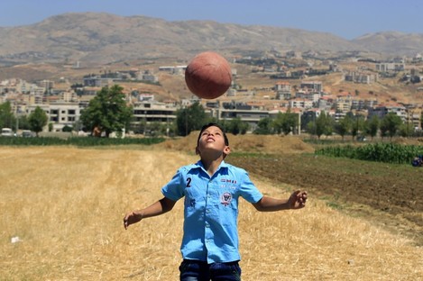 Syrian schoolchild Mouhannad al-Jassem, 11, who fled with his family from Idlib, plays soccer at a refugee camp in Saadnayel, in the Bekaa Valley in Lebanon.