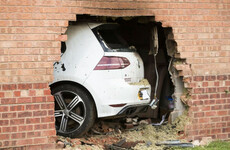 Four people injured after car crashes into house and catches fire