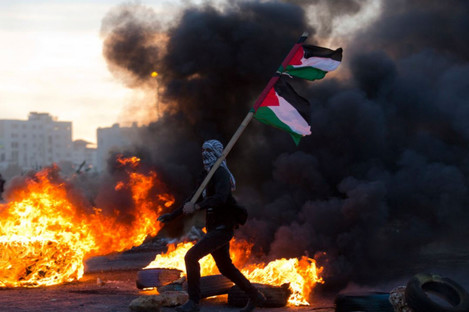 A Palestinian protester pictured yesterday during clashes with Israeli troops following protests against Trump's decision 