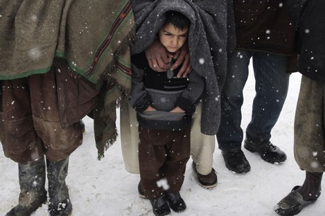 File photo: Internally displaced Afghans wait for blankets and winter clothing at a camp in Kabul, 20 February.