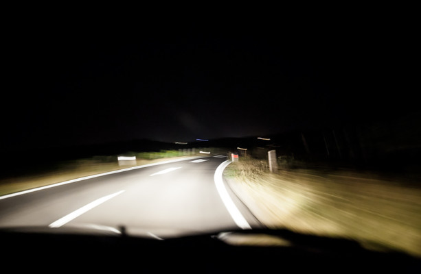 Night Car With Bright Headlights Approaching In The Dark