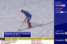 Peterborough defender Steven Taylor resorts to sweeping snow off the pitch mid-game
