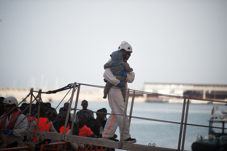A baby migrant, who was rescued from a dinghy in the Mediterranean Sea, is carried by rescue worker after his arrival at Port of Malaga