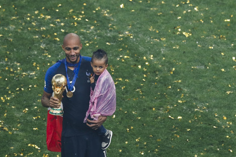 N'Zonzi holds the World Cup trophy and his child. 