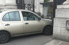 Woman arrested after car driven into gates of Government Buildings