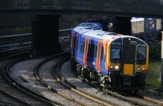 Cement mixing lorry falls on train in Surrey