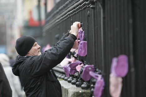 Abuse survivor Noel Brennan hangs baby shoes on the railings outside the Pro Cathedral during a demonstration in 2010.