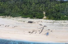 Men rescued from uninhabited Pacific island after writing SOS in sand