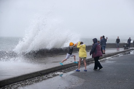 People are hit by waves on the Front Strand in Youghal, Co Cork, on Wednesday.