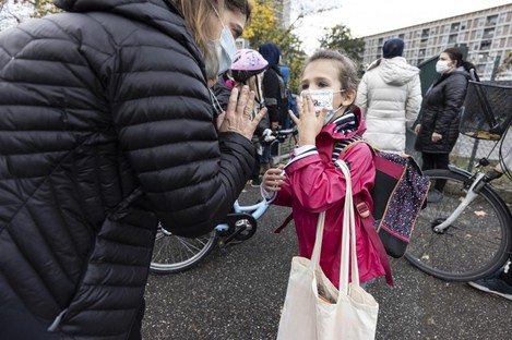 A mother and her daughter wave goodbye as school resumes with new sanitary precautions during the lockdown in Strasbourg, Eastern France which went into shutdown mode on Friday. 