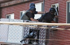 Booby-trapped: bomb squad to try and enter suspect shooter's apartment
