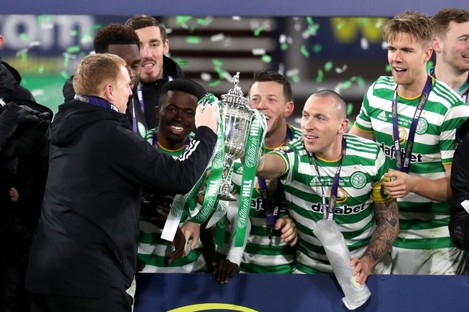 Celtic manager Neil Lennon takes the trophy from Scott Brown (right).