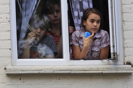 Children watch from their window during riots in Hackney, east London.