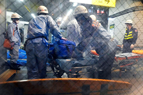 Rescuers prepare stretchers at Soshigaya Okura Station in Tokyo. 