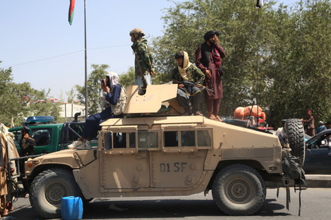 Taliban fighters on a military vehicle in Kabul.