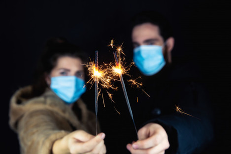 File photo of people wearing masks and holding sparklers 