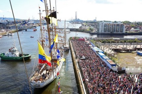 Crowds watch the ships as they sail out of Dublin Harbour on Sunday.