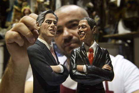 Italian Nativity scenes designer Genny Di Virgilio puts the final touches on two statuettes depicting President Barack Obama, right, and Republican rival Mitt Romney in his shop in Naples, Italy,