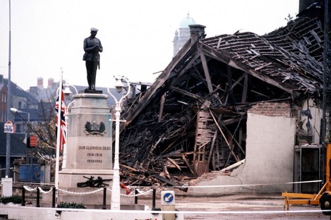 1987: The Cenotaph at Enniskillen with the devastated community centre in the background. 