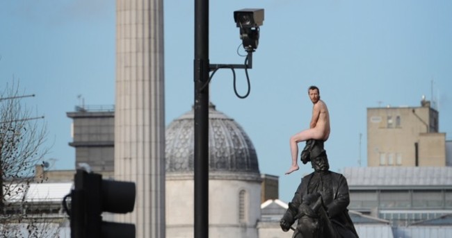 Naked man scales London statue