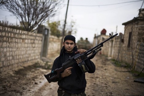A Free Syrian Army fighter poses as he carries his weapon in the northern province of Aleppo, Syria.