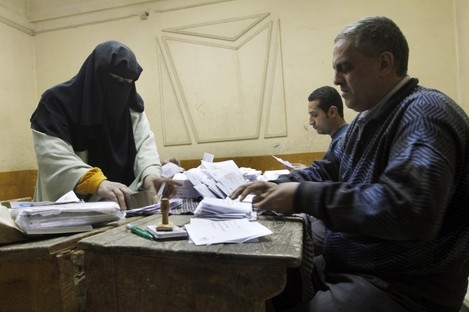 Egyptian referendum officials count votes at a polling station in Cairo after ballots were cast in the referendum on adopting a new constitution.
