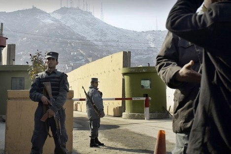 File photo: Afghan police officers stand guard outside of Kabul police headquarters, where a an American contractor was killed, in Kabul, Afghanistan.
