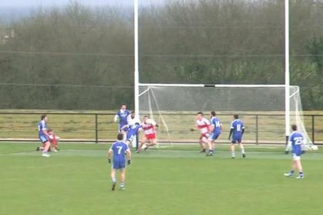 The Ballinderry Shamrocks player heads the ball into the net.