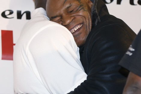 Former heavyweight champion Mike Tyson hugs fellow former champion Evander Holyfield during a promotional event for Holyfield's Real Deal barbecue sauce at a Chicago grocery store yesterday.