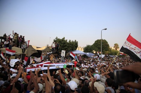 Supporters of Egypt's ousted President Mohammed Morsi carry coffins, covered with the national flag, of four men killed after Egyptian troops opened fire on mostly Islamist protesters marching on a Republican Guard headquarters Friday, in Cairo.