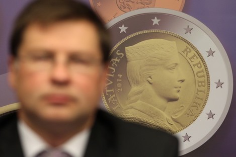 A reproduction of a Latvian euro coin is displayed, as Latvian Prime Minister Valdis Dombrovskis addresses the media on the adoption of the euro, at the European Council building in Brussels yesterday