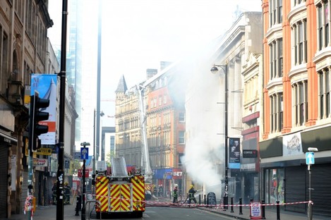 Firefighters at the scene of a fire at Paul's Hair World in Oldham Street, Manchester, where firefighter Stephen Hunt, 38, was killed whilst tackling the blaze at the city centre shop.