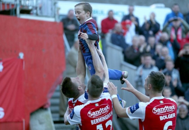 Anto Flood celebrates scoring his side's second goal of the game by lifting up a young supporter who ran onto the pitch 13/10/2013