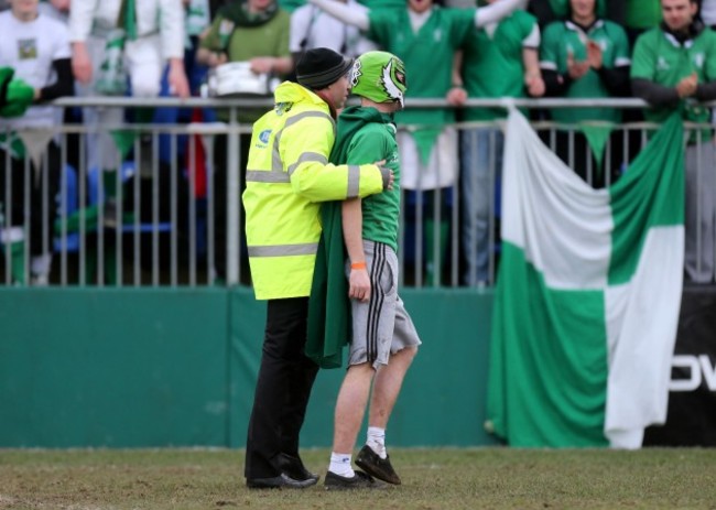 A Gonzaga fan is escorted off the pitch