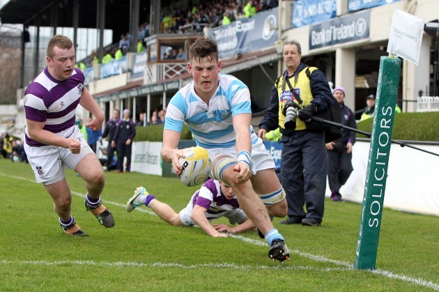 Conor Oliver goes over for a try despite the efforts of John Moloney