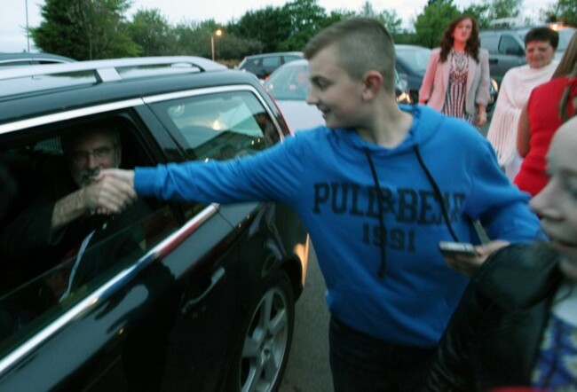: Gerry Adams shakes hands with a young