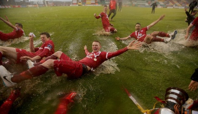 Sligo Rovers players celebrate on the rain soaked pitch at the end of the game