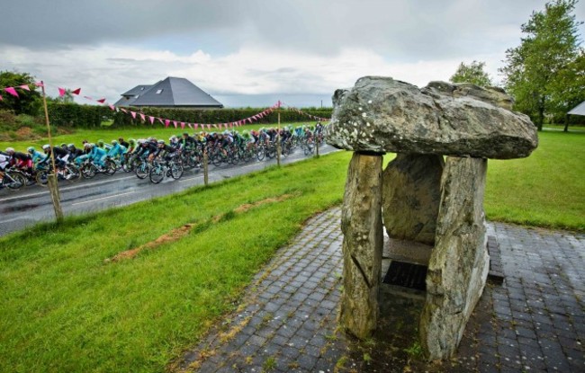 The peloton pass by the Monasterboice dolmen