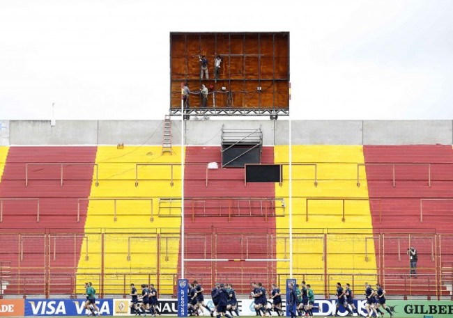 The Ireland team warm up in front of workmen at the stadium