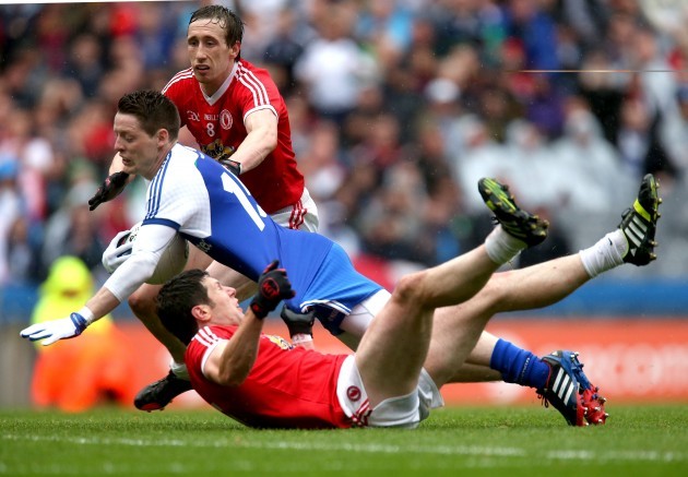 Conor McManus is dragged down by Sean Cavanagh and Colm Cavanagh