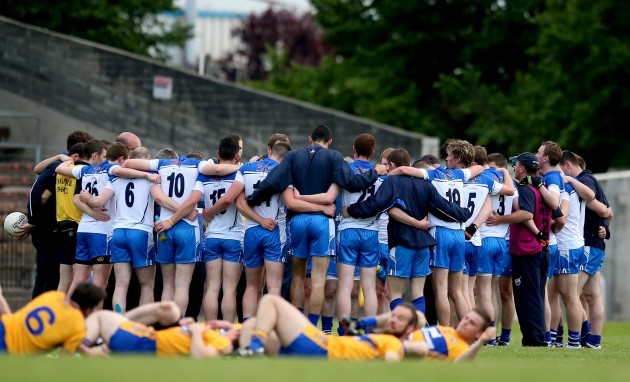 The Waterford team huddle after the game as the Clare team warm down