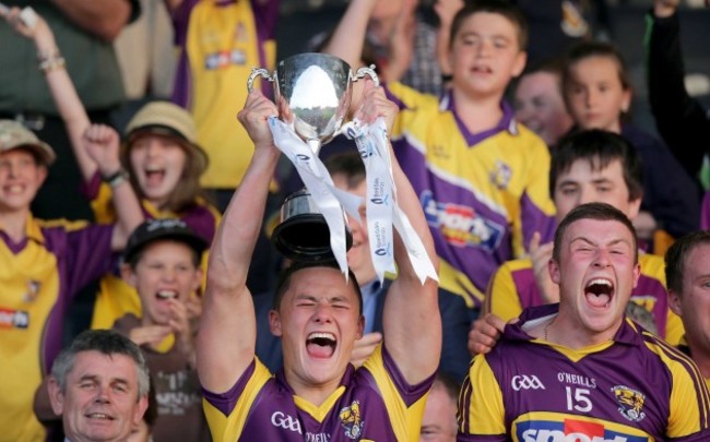 Lee Chin raises the Leinster U21 trophy alongside teammate Rhys Clarke