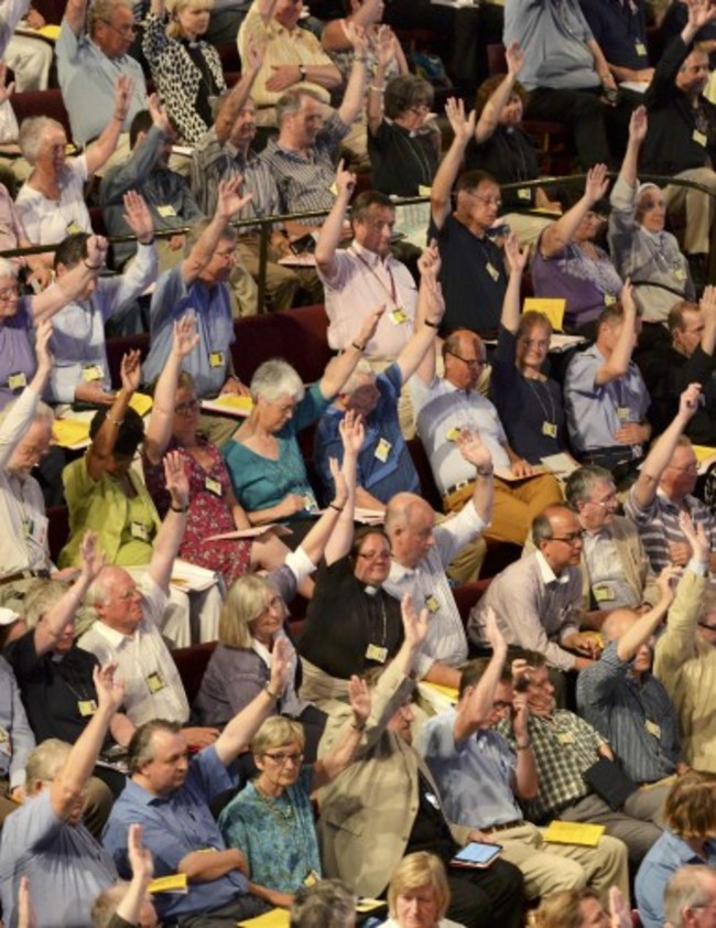 Members of the Church of England's Synod vote on one of the motions during the session which approved the consecration of women bishops, in York