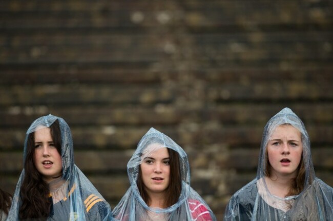 Fans sing the national anthem in the rain